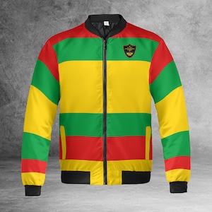 May include: A black bomber jacket with a zipper closure. The jacket has horizontal stripes in red, yellow, and green. A black patch with a gold star and the text "Black Star" is on the left side of the chest.