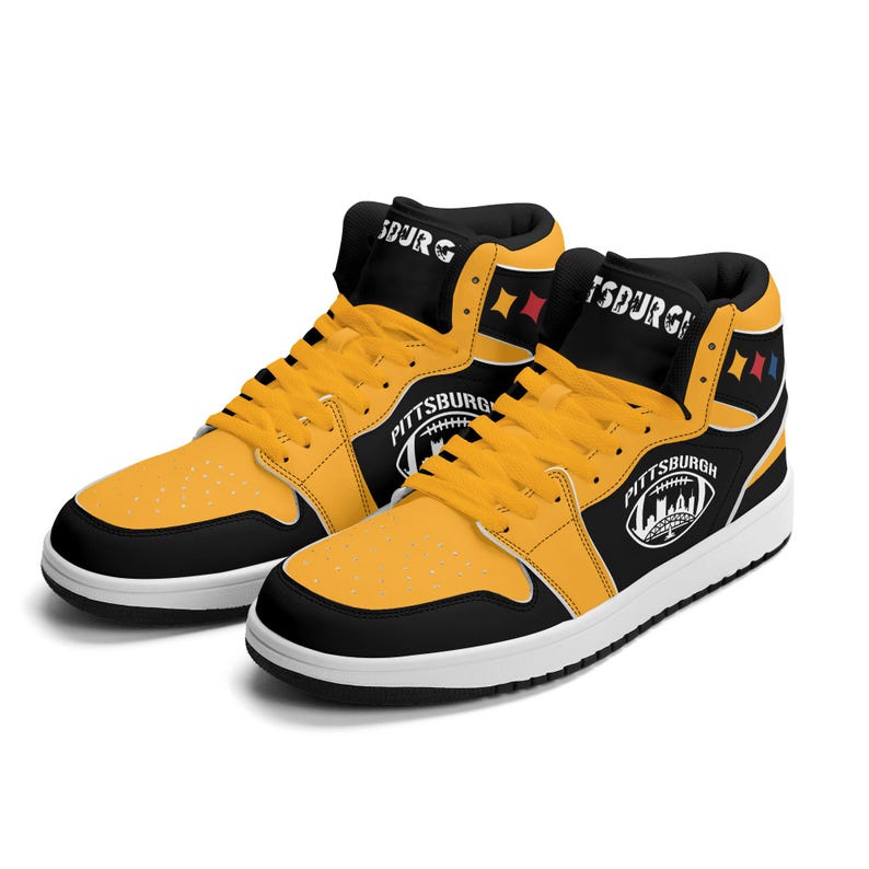 Peut inclure: Paire de baskets montantes jaunes, noires et blanches. Les baskets ont des lacets jaunes, un bout noir et un talon noir. Le mot "PITTSBURGH" est imprim&eacute; sur le c&ocirc;t&eacute;, avec un graphisme de football.