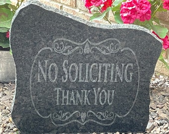 May include: A black granite sign with a decorative border and the text "No Soliciting Thank You" in white lettering.