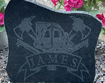 May include: Black granite stone with a firefighter helmet, crossed axes, and the name "JAMES" engraved on a banner.