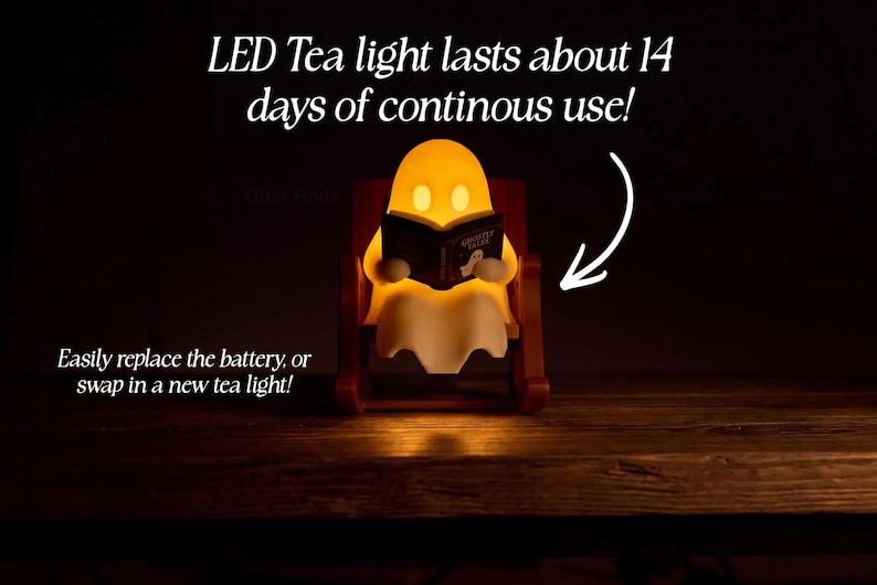 Front view of a glowing reading ghost in its chair. Text states: LED Tea light lasts about 14 days of continuous use! Easily replace the battery or swap in a new tea light!