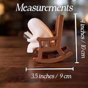 Measurements graphic showing the white reading ghost in a brown rocking chair from the side. Vertical measurement is 4 inches / 10 cm; horizontal measurement across the rockers is 3.5 inches / 9 cm.