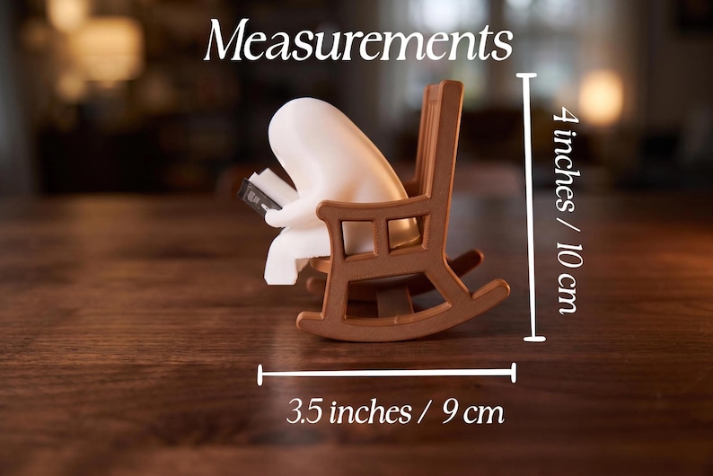Measurements graphic showing the white reading ghost in a brown rocking chair from the side. Vertical measurement is 4 inches / 10 cm; horizontal measurement across the rockers is 3.5 inches / 9 cm.