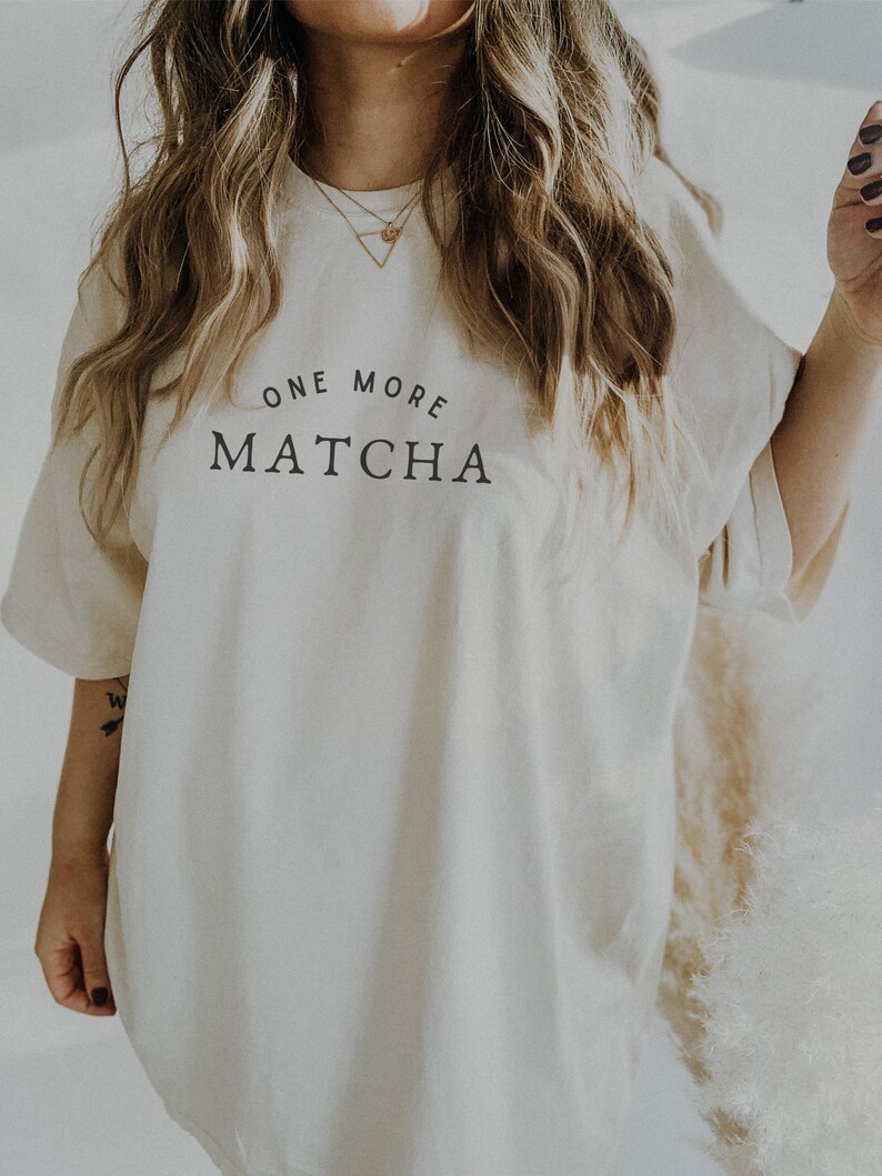 May include: A white oversized t-shirt with the text "ONE MORE MATCHA" printed on the front.