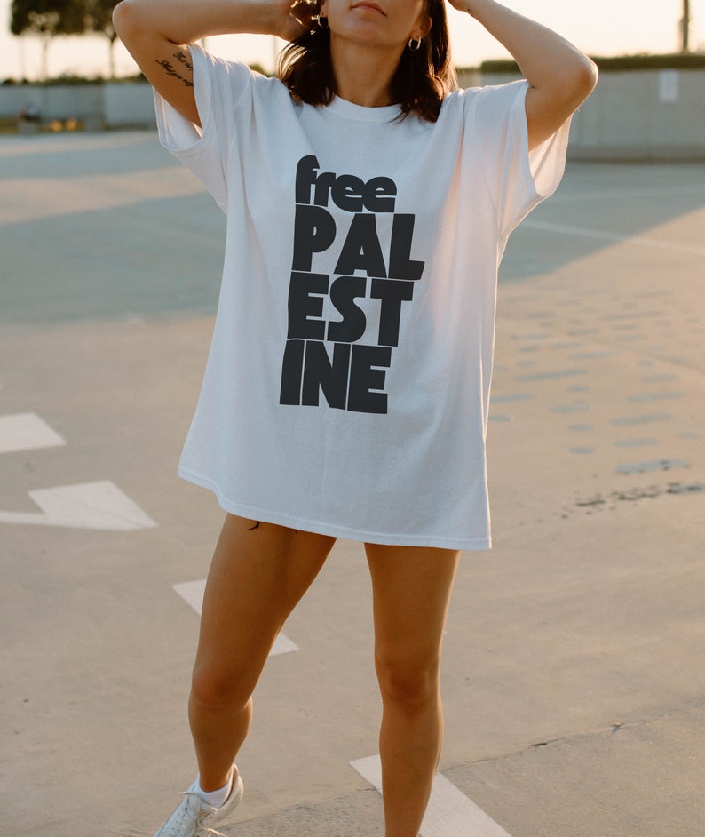 May include: A white t-shirt with black text that reads "free PAL estine".