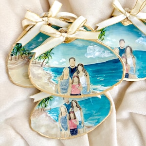 May include: Three decorative seashell ornaments featuring hand-painted scenes of a family standing on a beach by the ocean. Each shell has a gold-painted edge and is topped with a cream-colored satin ribbon bow for hanging as a holiday decoration.