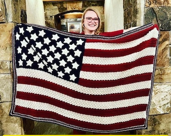 May include: A crochet blanket in the colors of the American flag. The blanket is held up by a person, and the text "This is a Digital Pattern, not a Physical Product" is visible at the bottom of the image.