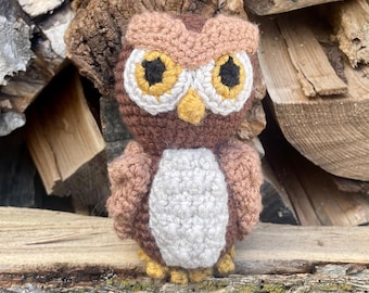 May include: A crocheted owl figurine with brown, tan, yellow, and white yarn. The owl has large yellow eyes with black pupils, a white chest, and a tan beak. The text at the bottom reads: "This is a Digital Pattern, not a Physical Product."