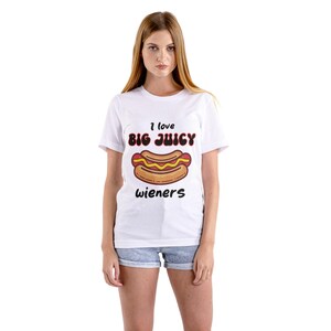 May include: White t-shirt with a graphic of a hot dog and the text "I love big juicy wieners".