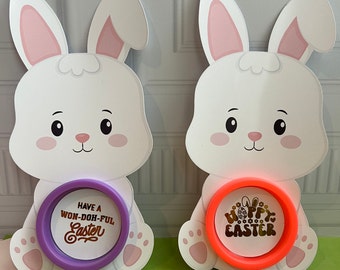 May include: Two white bunny shaped Easter decorations with a purple and orange circle with gold text. The purple circle says "Have a Won-Doh-Ful Easter" and the orange circle says "Happy Easter".