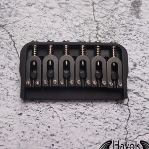 May include: Black six-string guitar bridge with chrome hardware and adjustable saddles.