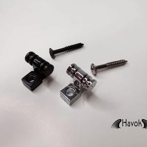 Puede incluir: Dos botones de correa de guitarra, uno negro y uno cromado, con dos tornillos.