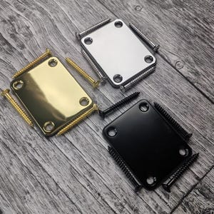 May include: Three rectangular metal guitar neck plates with four corner screw holes each. The set includes one gold-tone plate with matching gold screws, one silver-tone chrome plate with silver screws, and one matte black plate with black screws.