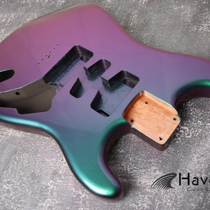 May include: An electric guitar body in purple and green with a wood neck plate. The body is unpainted and ready for assembly. Havok Custom Guitars.