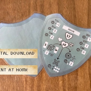 May include: A printable character sheet for a tabletop role-playing game. The sheet is blue and features a moon with the number 17 inside. The sheet also includes stats for strength, dexterity, constitution, intelligence, wisdom, and charisma. The sheet is labeled "Moon".
