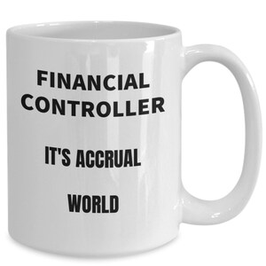 May include: White ceramic coffee mug with black text that reads "Financial Controller It's Accrual World".