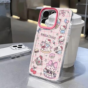 Puede incluir: Funda transparente para tel&eacute;fono con borde rosa, con ilustraciones de Hello Kitty sobre un fondo de cuadros rosas. La funda incluye im&aacute;genes de Hello Kitty con lazos, helados y otros dise&ntilde;os bonitos. El texto "Hello Kitty" tambi&eacute;n es visible.