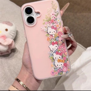 Puede incluir: Funda de tel&eacute;fono rosa con personajes de Hello Kitty y detalles florales. El dise&ntilde;o presenta caras de Hello Kitty con lazos, rodeadas de flores y hojas coloridas.