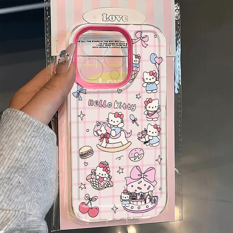 Puede incluir: Funda transparente para tel&eacute;fono con borde rosa y gr&aacute;ficos de Hello Kitty. La funda presenta un patr&oacute;n de cuadr&iacute;cula e ilustraciones de Hello Kitty, lazos, estrellas y alimentos. La palabra "Love" est&aacute; en la parte superior.