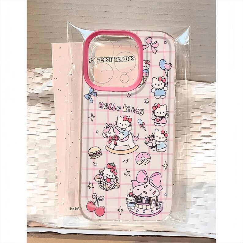 Puede incluir: Funda transparente para tel&eacute;fono con borde rosa y dise&ntilde;o de Hello Kitty. La funda presenta un patr&oacute;n de cuadr&iacute;cula e ilustraciones de Hello Kitty con varios accesorios, incluyendo un balanc&iacute;n, helado y globos. El texto "SWEET BABE" es visible.