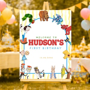 Może przedstawiać: Spersonalizowany znak urodzinowy z napisem "Welcome to Hudson's First Birthday". Znak jest ozdobiony ilustracjami z kreskówek zwierząt i postaci, na żółto-białym tle w paski z niebieską obwódką. Wyświetlana jest również data 12.06.2016.