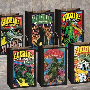 May include: Six black gift bags with brown paper handles. Each bag features a different vintage comic book cover of Godzilla, the King of Monsters. The bags have a retro comic book style with bold colours and dynamic illustrations.