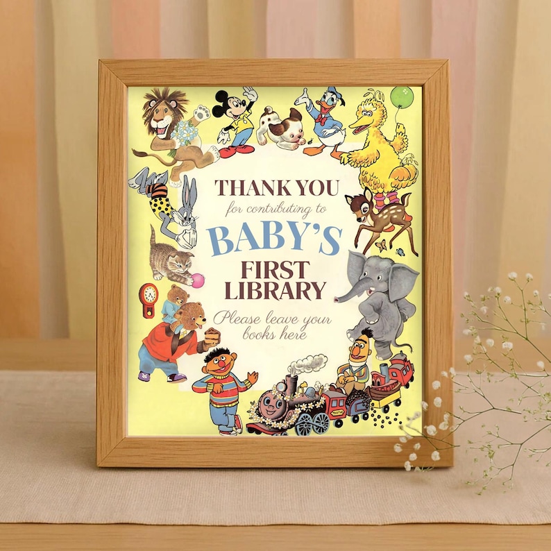 K&ouml;nnte beinhalten: Holzgerahmter Druck mit gelbem Hintergrund und dem Text "THANK YOU for contributing to BABY'S FIRST LIBRARY". Der Druck ist von Zeichentrickfiguren umgeben, darunter Micky Maus und Bugs Bunny. Unten ist ein Zug.