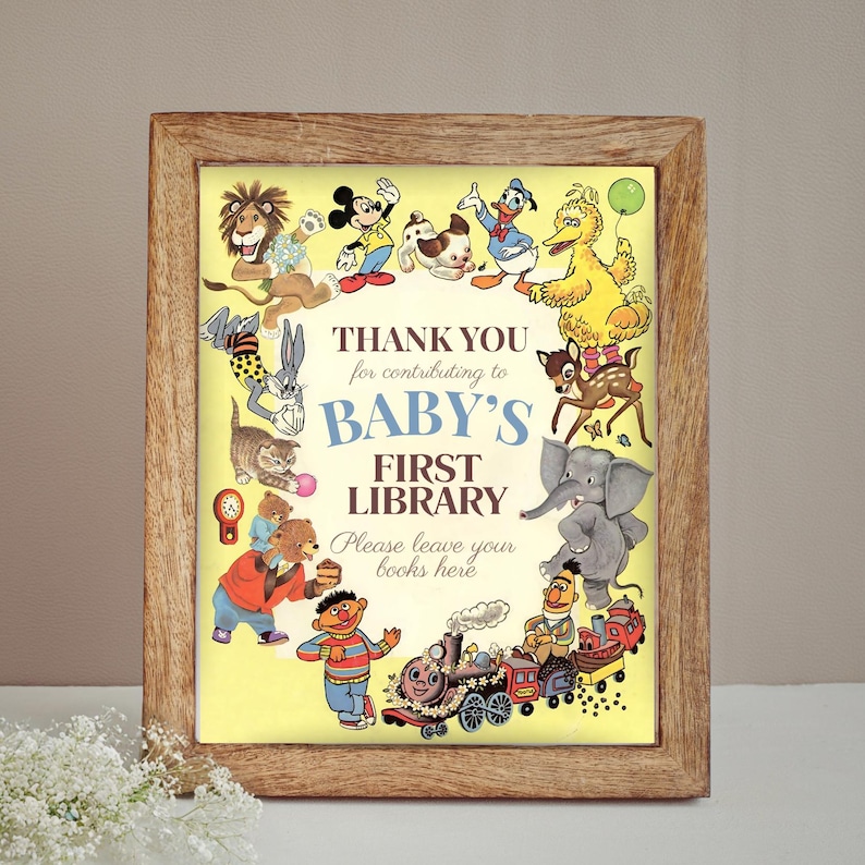 K&ouml;nnte beinhalten: Ein gerahmter Druck mit gelbem Hintergrund und einer Sammlung von Zeichentrickfiguren, die den Text "BABY'S FIRST LIBRARY" umgeben. Der Rahmen besteht aus hellbraunem Holz. Der Druck zeigt Figuren wie Mickey Mouse und Big Bird.