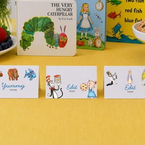 Op de afbeelding: Een kleurrijk stilleven met kinderboeken, koekjes en tafelkaarten. De boeken zijn onder meer "The Very Hungry Caterpillar" en "Alice in Wonderland". De tafelkaarten bevatten illustraties en de woorden "Yummy Food" en "Edit Text."