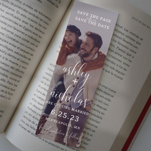 Op de afbeelding: Een save-the-date-bladwijzer met een foto van een lachend stel. De bladwijzer is wit met zwarte tekst die "Save the Page with our Save the Date" zegt. De namen van het stel zijn Ashley en Nicholas, en de datum is 6.25.23. De locatie is Minneapolis, MN. De tekst "Formal Invitation to follow" staat onderaan de bladwijzer.