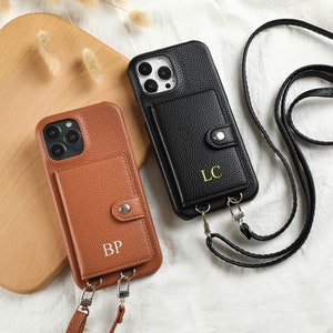 Puede incluir: Dos fundas para teléfono con ranuras para tarjetas y correas ajustables. La funda marrón tiene las iniciales "BP" y la funda negra tiene las iniciales "LC".
