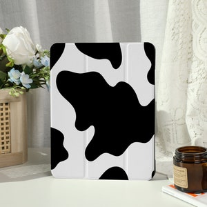 Op de afbeelding: Een iPad-hoes met een zwart-witte koe-print. De hoes is gemaakt van duurzaam materiaal en heeft een strak ontwerp.