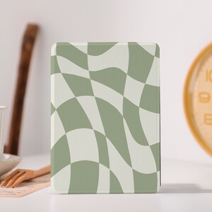 Pode incluir: Uma capa para leitor de e-books com um padrão xadrez ondulado verde e branco.