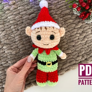 May include: Crochet pattern for a green and red elf doll with a white hat. The pattern is available as a PDF download.  PDF PATTERN