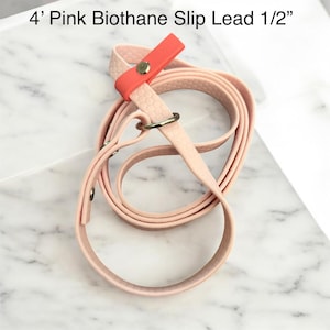 May include: A pink Biothane slip lead, 4 feet long, with a 1/2 inch width. The lead features a coral-colored accent and a metal ring. The text "4' Pink Biothane Slip Lead 1/2" is visible at the top of the image.