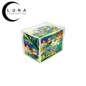 May include: Clear acrylic display case featuring a colorful Pokemon design. The case has a rectangular shape with a lid and a slanted opening. The case is designed to hold trading cards and has the Luna Fabrication logo.