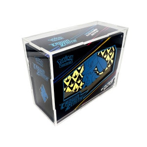 May include: A clear acrylic display case encasing a Pokémon Crown Zenith Elite Trainer Box Plus. The box features a black background with blue and yellow accents, and the Pokémon logo. The case protects the box from damage.