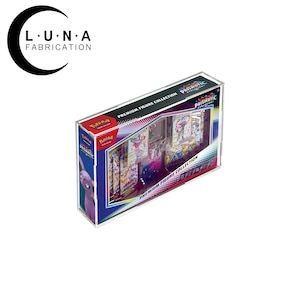 May include: A clear, rectangular display case containing a Pokemon Premium Figure Collection. The box features the text "PRISMATIC EVOLUTION" and "PREMIUM FIGURE COLLECTION". The Luna Fabrication logo is in the upper left corner.