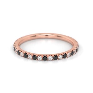 K&ouml;nnte beinhalten: Ein Ros&eacute;gold-Bandring mit einer Reihe abwechselnder schwarzer und wei&szlig;er Diamanten.