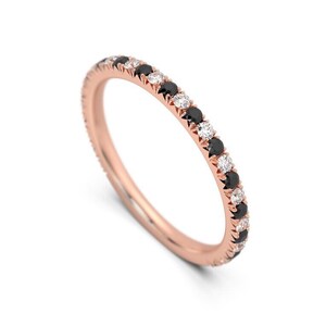 K&ouml;nnte beinhalten: Ein Ros&eacute;gold-Bandring mit abwechselnd schwarzen und wei&szlig;en Diamanten.