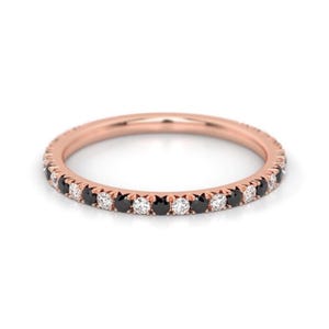 K&ouml;nnte beinhalten: Ein Ros&eacute;gold-Bandring mit abwechselnd schwarzen und wei&szlig;en Diamanten.