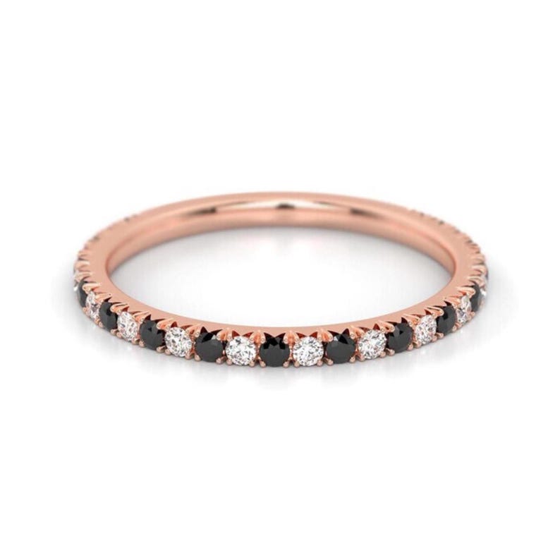 K&ouml;nnte beinhalten: Ein Ros&eacute;gold-Bandring mit abwechselnd schwarzen und wei&szlig;en Diamanten.