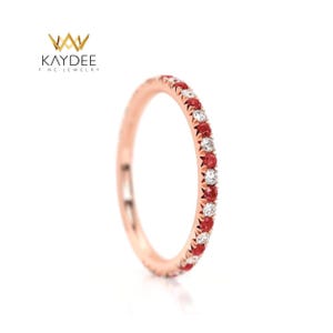 May include: Rose gold band ring with alternating red and white gemstones. The ring is a delicate design, suitable for everyday wear. The Kaydee Fine Jewelry logo is in the upper left corner.