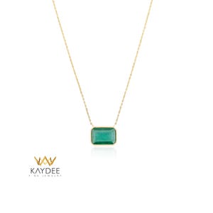 Op de afbeelding: Een gouden ketting met een rechthoekige smaragdgroene edelsteen hanger. De hanger is gezet in een gouden bezel en hangt aan een fijne gouden ketting. De ketting wordt gepresenteerd op een witte achtergrond. Het merklogo "KAYDEE FINE JEWELRY" staat in de linker benedenhoek.