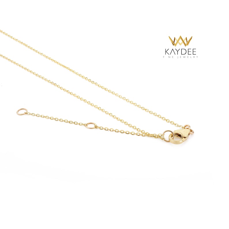 Op de afbeelding: Een delicate goudkleurige ketting met een fijne ketting en een karabijnsluiting. De ketting wordt getoond tegen een witte achtergrond. De merknaam "KAYDEE FINE JEWELRY" is rechtsboven zichtbaar.