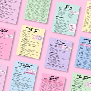 May include: A selection of medical reference cards in various pastel colours, including pink, blue, and yellow, against a pink backdrop. The cards display titles such as "Heart Rate Too High" and "Blood Pressure Too Low", with detailed medical information.