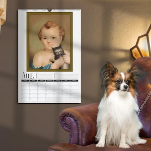 May include: A wall calendar for the month of August featuring a portrait of a child holding a small black kitten. The calendar has a white background with black text and a grid layout for the days of the month, suspended by a metal spiral binding.