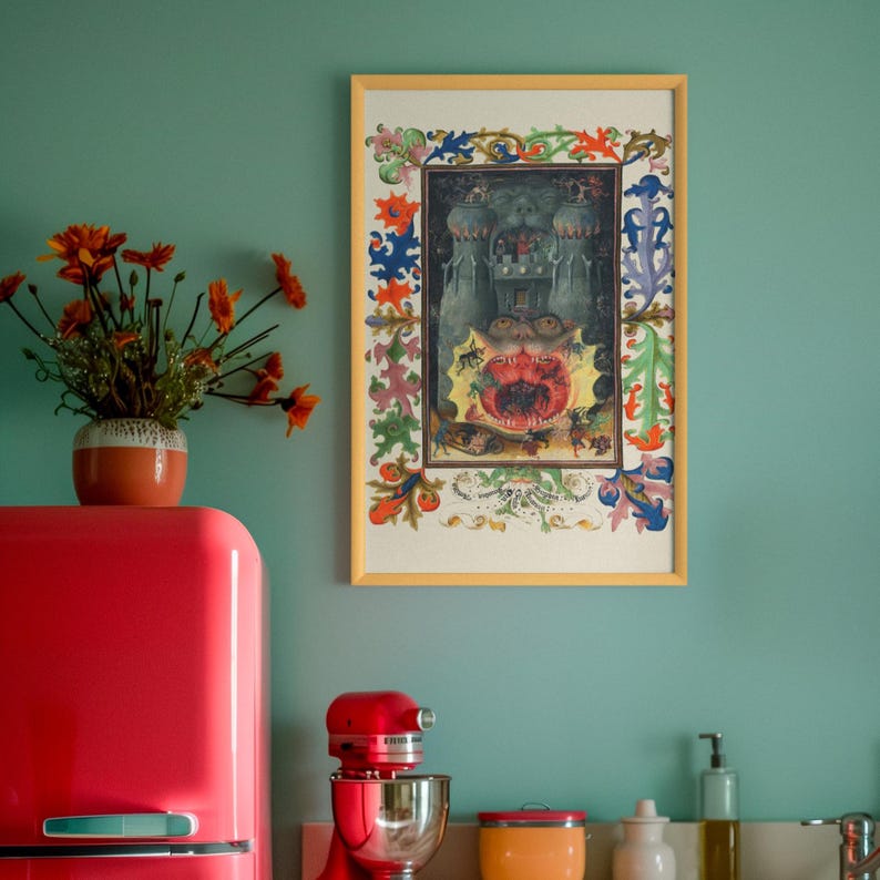 May include: A framed rectangular print featuring a medieval-style illustration of a castle structure with a large, open, toothy mouth at the base, surrounded by a colourful, intricate floral and vine border in shades of blue, green, red, and orange.
