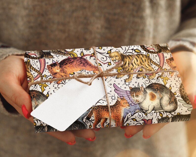 May include: A wrapped gift featuring a decorative paper with illustrations of various cats and felines, tied with twine and a blank white tag. The gift wrap has a cream background with colorful cat illustrations.