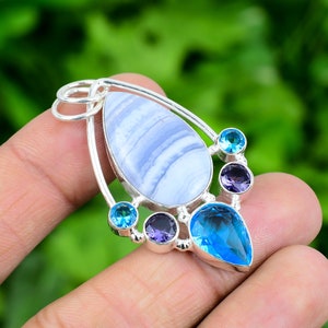 May include: A silver pendant featuring a blue agate gemstone, surrounded by smaller blue and purple gemstones.